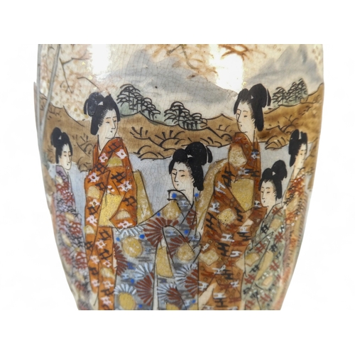 322 - A pair of late 19th century Satsuma vases - decorated in panels showing elegant ladies in a landscap... 