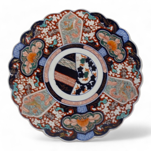 330 - An early 20th century Imari charger - decorated with foliage in typical palette with a scalloped bor... 