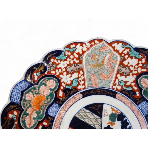 330 - An early 20th century Imari charger - decorated with foliage in typical palette with a scalloped bor... 