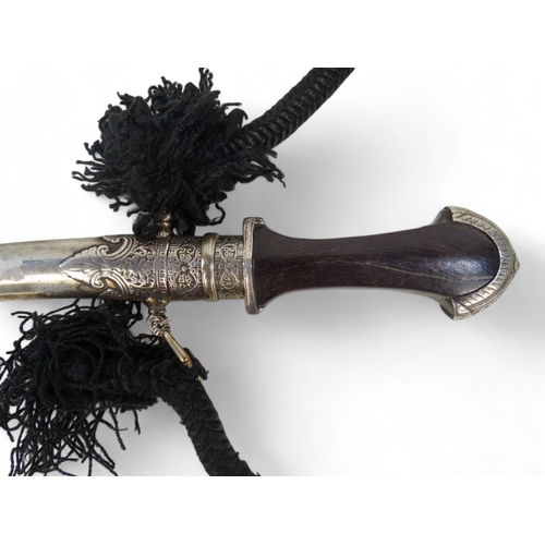 437 - A late 19th century jambiya - the hardwood hilt with white metal mounts and sheath and black woven c... 