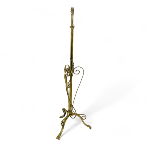 49 - A late Victorian brass adjustable standard lamp - with tripod base with Art Nouveau style supports, ... 