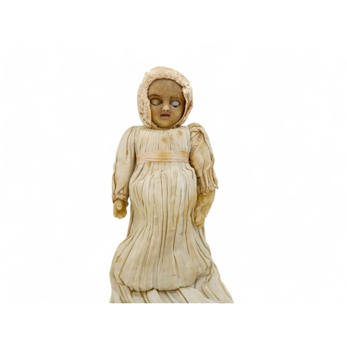 518 - An early Victorian wax head doll - in period clothing wearing a bonnet, with wax arms and calico bod... 