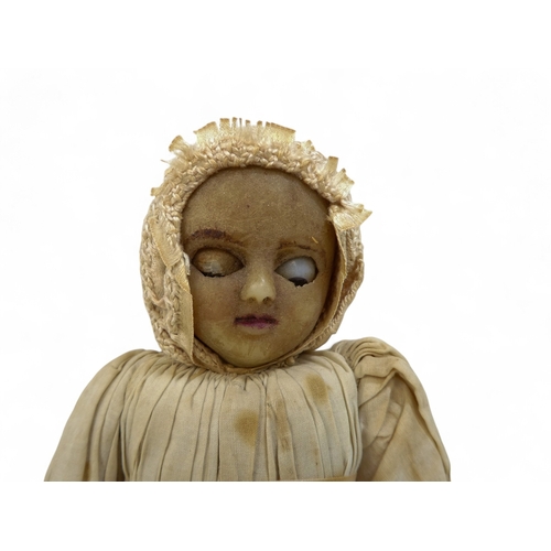 518 - An early Victorian wax head doll - in period clothing wearing a bonnet, with wax arms and calico bod... 