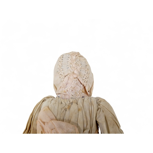 518 - An early Victorian wax head doll - in period clothing wearing a bonnet, with wax arms and calico bod... 