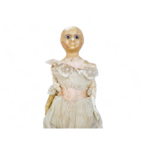 519 - An early Victorian wax head doll - in period clothing incorporating lace trim, with brown glass eyes... 