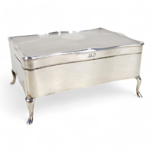 526 - A silver jewellery casket - Birmingham 1912, rectangular with engine turned hinged lid and velvet fi... 