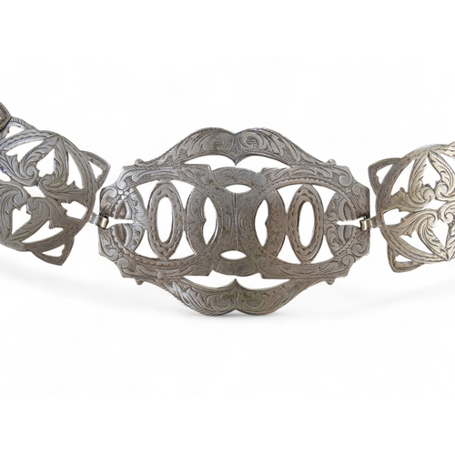 582 - An early 20th century silver plated belt - formed from interlinked pierced and foliate engraved squa... 