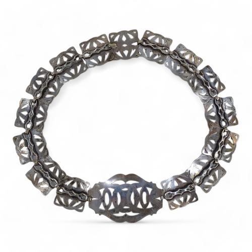 582 - An early 20th century silver plated belt - formed from interlinked pierced and foliate engraved squa... 