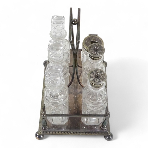 586 - An early 20th century silver plated cruet set - with clear glass square cut bottles within a rectang... 