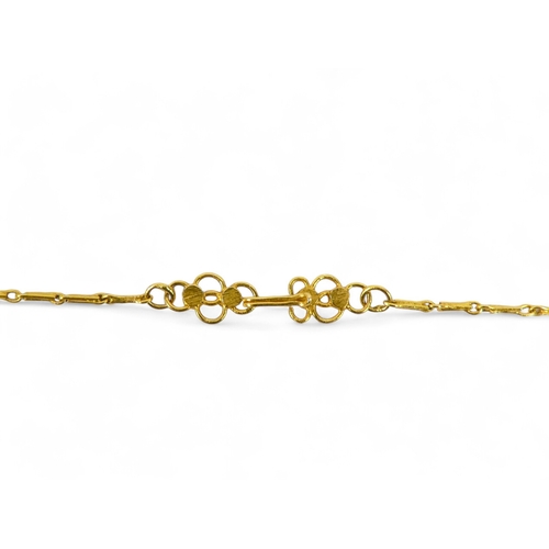 617 - A gilt wreath pendant and chain - probably high carat gold, formed from seven rose buds, on a fine l... 