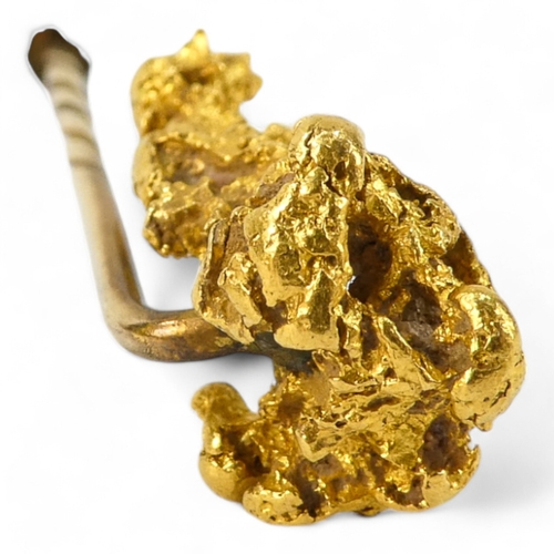 621 - A natural form gold nugget - fashioned into a stick pin, 8.8g.