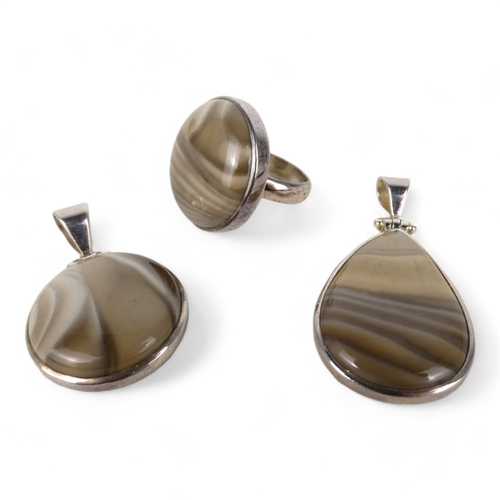 638 - A grey polished hardstone pendant - set within a silver mount, together with another and a similar r... 