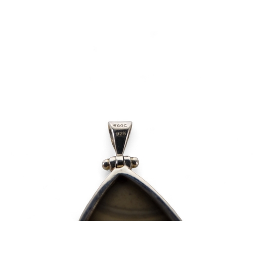 638 - A grey polished hardstone pendant - set within a silver mount, together with another and a similar r... 