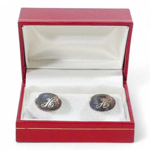 639 - A pair of sterling silver cufflinks - the oval buttons engraved with the letter 'H', weight 15.5g, b... 