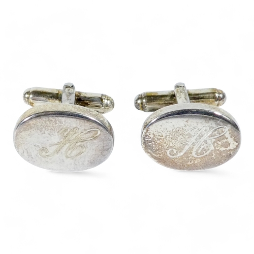 639 - A pair of sterling silver cufflinks - the oval buttons engraved with the letter 'H', weight 15.5g, b... 