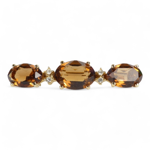 645 - A Christian Dior yellow metal brooch - set oval faceted brown stones and white stones, length 6cm.