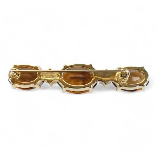 645 - A Christian Dior yellow metal brooch - set oval faceted brown stones and white stones, length 6cm.