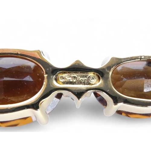 645 - A Christian Dior yellow metal brooch - set oval faceted brown stones and white stones, length 6cm.