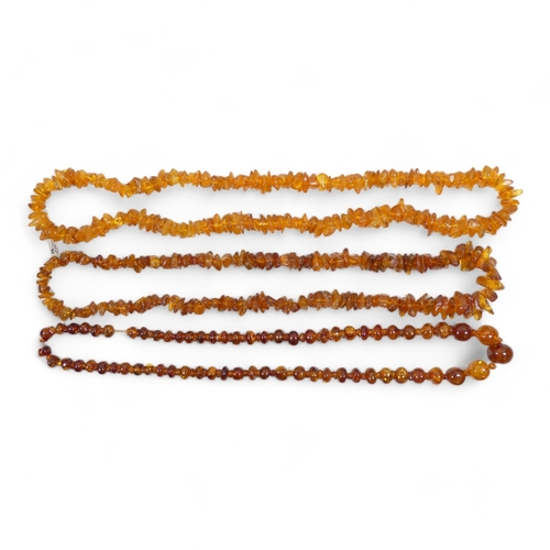 662 - A string of graduated asymmetrical amber beads - 68cm long, together with two further strings of amb... 