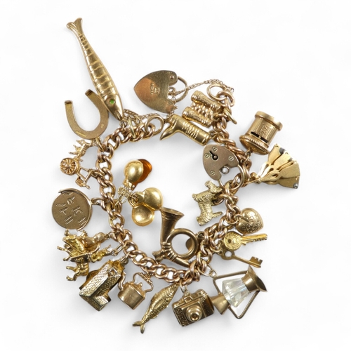 665 - A 9ct gold curb link charm bracelet - with twenty charms mostly marked as 9ct, 49.2g.