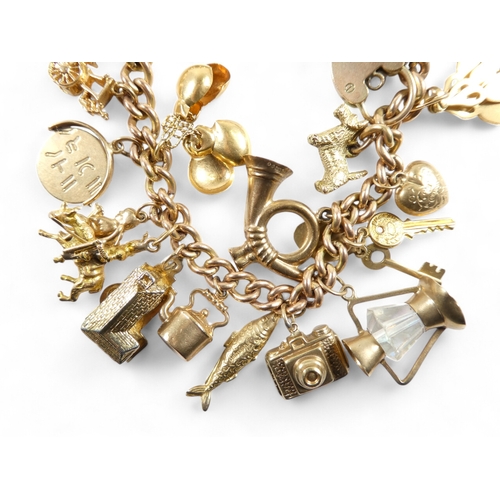 665 - A 9ct gold curb link charm bracelet - with twenty charms mostly marked as 9ct, 49.2g.