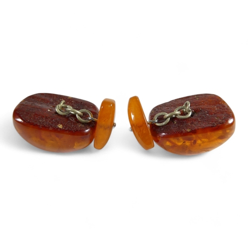 667 - A pair of amber cufflinks - of domed rectangular form linked by chain to smaller torpedoes, 14g.