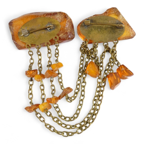 668 - An amber brooch - the two pieces linked by chains with amber drops, 32g.