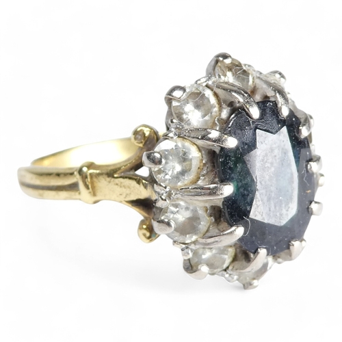 680 - A 9ct sapphire and diamond ring - the claw set oval central stone within a band of diamonds, size R,... 