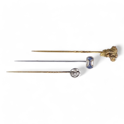 685 - A gold stick pin - as a natural nugget, 4.9g, together with two further stick pins, one floral set w... 