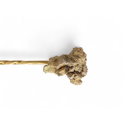 685 - A gold stick pin - as a natural nugget, 4.9g, together with two further stick pins, one floral set w... 