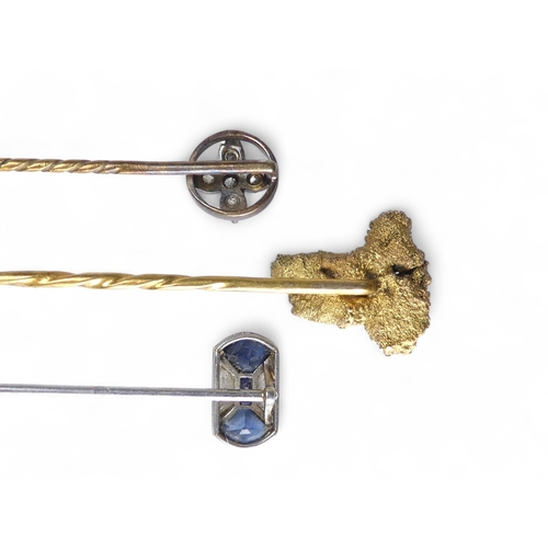 685 - A gold stick pin - as a natural nugget, 4.9g, together with two further stick pins, one floral set w... 