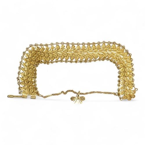 686 - A yellow metal bracelet - of pierced foliate form linked by chain, stamped 21ct, 37.8g.