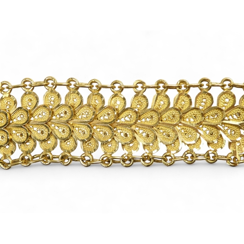 686 - A yellow metal bracelet - of pierced foliate form linked by chain, stamped 21ct, 37.8g.