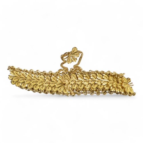 686 - A yellow metal bracelet - of pierced foliate form linked by chain, stamped 21ct, 37.8g.