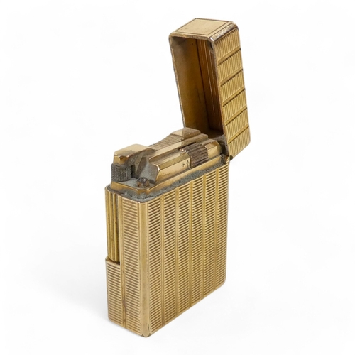 69 - A vintage Dupont Rollagas lighter - gilt metal engine turned, 5cm high.