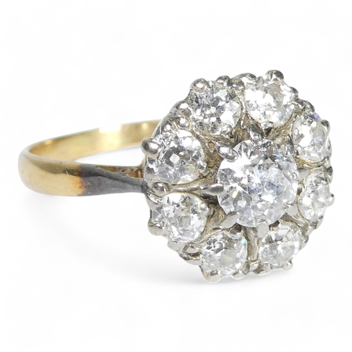 690 - An 18ct diamond cluster ring - with a central claw set stone, approx. 0.75ct, within a band of small... 