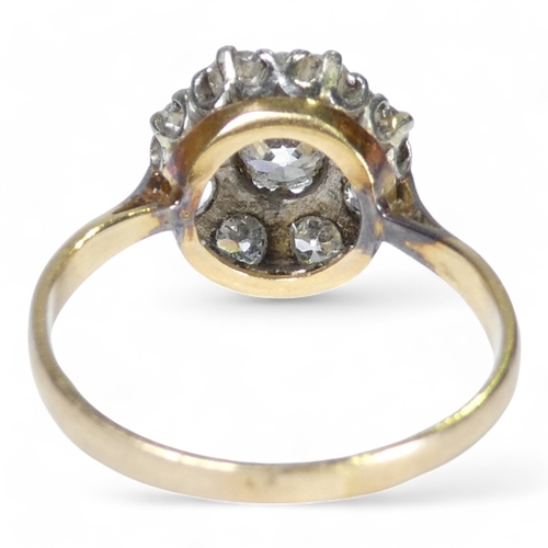 690 - An 18ct diamond cluster ring - with a central claw set stone, approx. 0.75ct, within a band of small... 