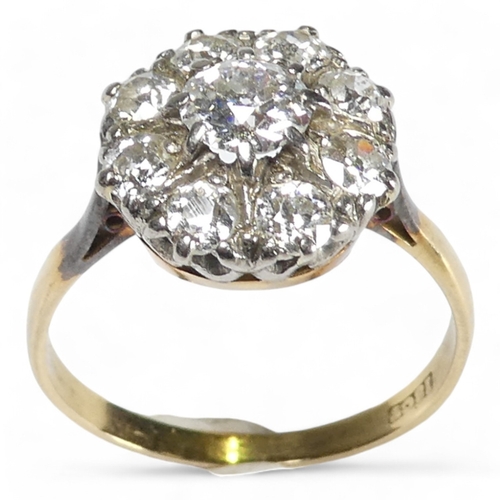 690 - An 18ct diamond cluster ring - with a central claw set stone, approx. 0.75ct, within a band of small... 