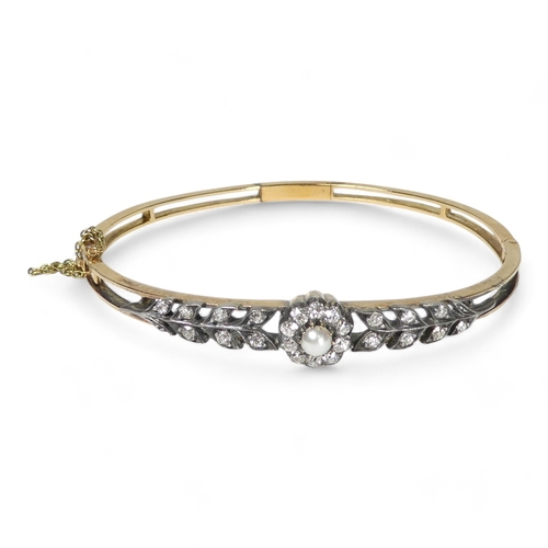 691 - A diamond and pearl set bangle - the claw set pearl within a band of diamonds flanked by foliage, 13... 