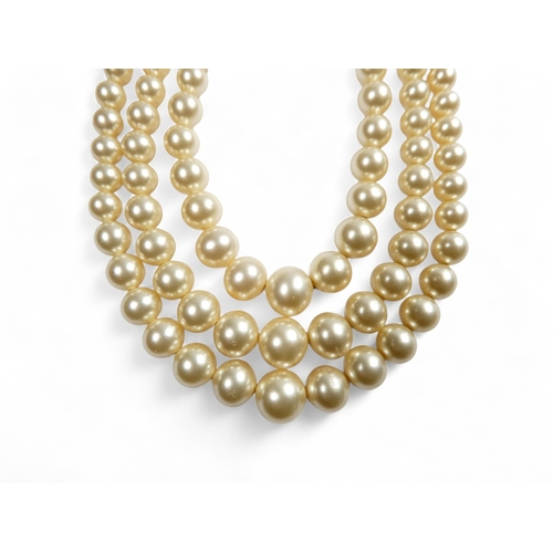 692 - A three string set of graduated pearls - with a 9ct gold clasp, 36cm long.