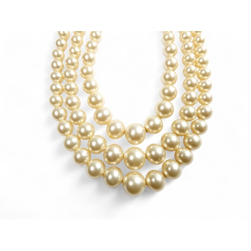 692 - A three string set of graduated pearls - with a 9ct gold clasp, 36cm long.