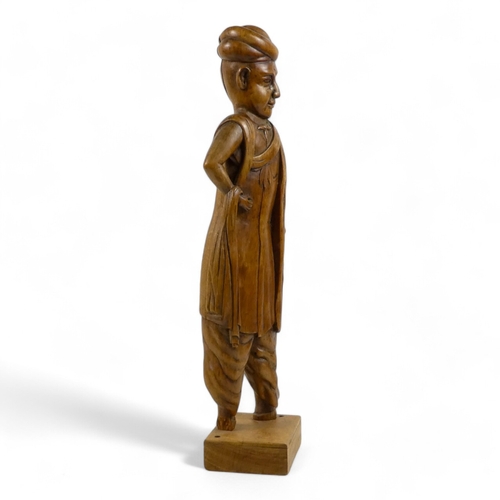 7 - A late 19th century carved oriental hardwood figure - wearing a turban and traditional clothes with ... 