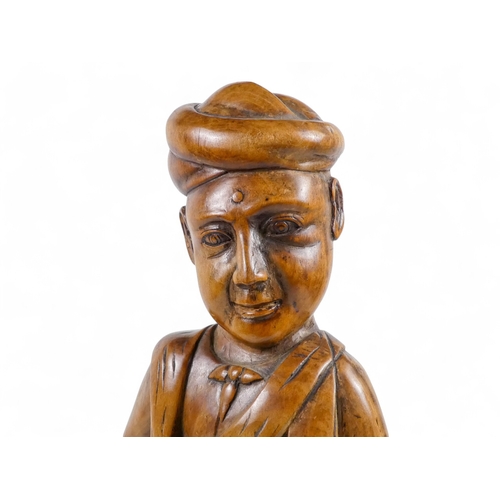 7 - A late 19th century carved oriental hardwood figure - wearing a turban and traditional clothes with ... 