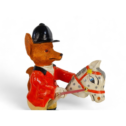 86 - A 20th century fox figure - wearing hunting pink and astride a hobby horse, 53cm high.