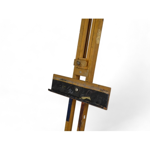 89 - A 20th century beech artist's studio easel - of folding tripod form with some paint transfer, fully ... 