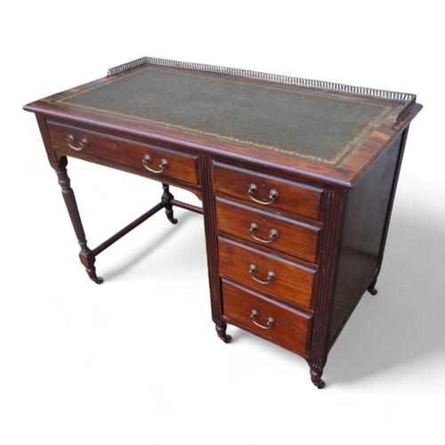 946 - An Edwardian mahogany desk - of asymmetrical form, the rectangular leather inset top with brass gall... 