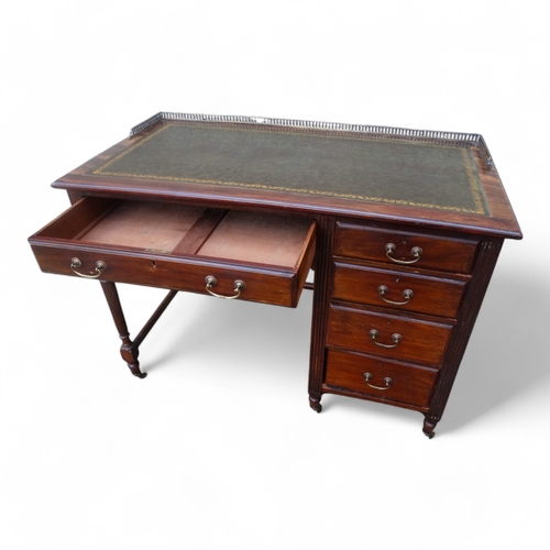 946 - An Edwardian mahogany desk - of asymmetrical form, the rectangular leather inset top with brass gall... 