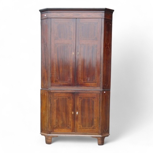 967 - A George III mahogany standing corner cupboard - with a pair of doors enclosing shelves, the lower s... 