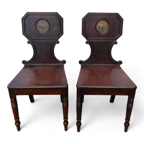 971 - A pair of George IV mahogany hall chairs - the tablet shaped backs with canted corners and decorated... 