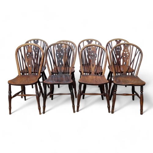 979 - A 19th century harlequin set of eight ash and elm wheel back Thames Valley chairs - with pierced spl... 